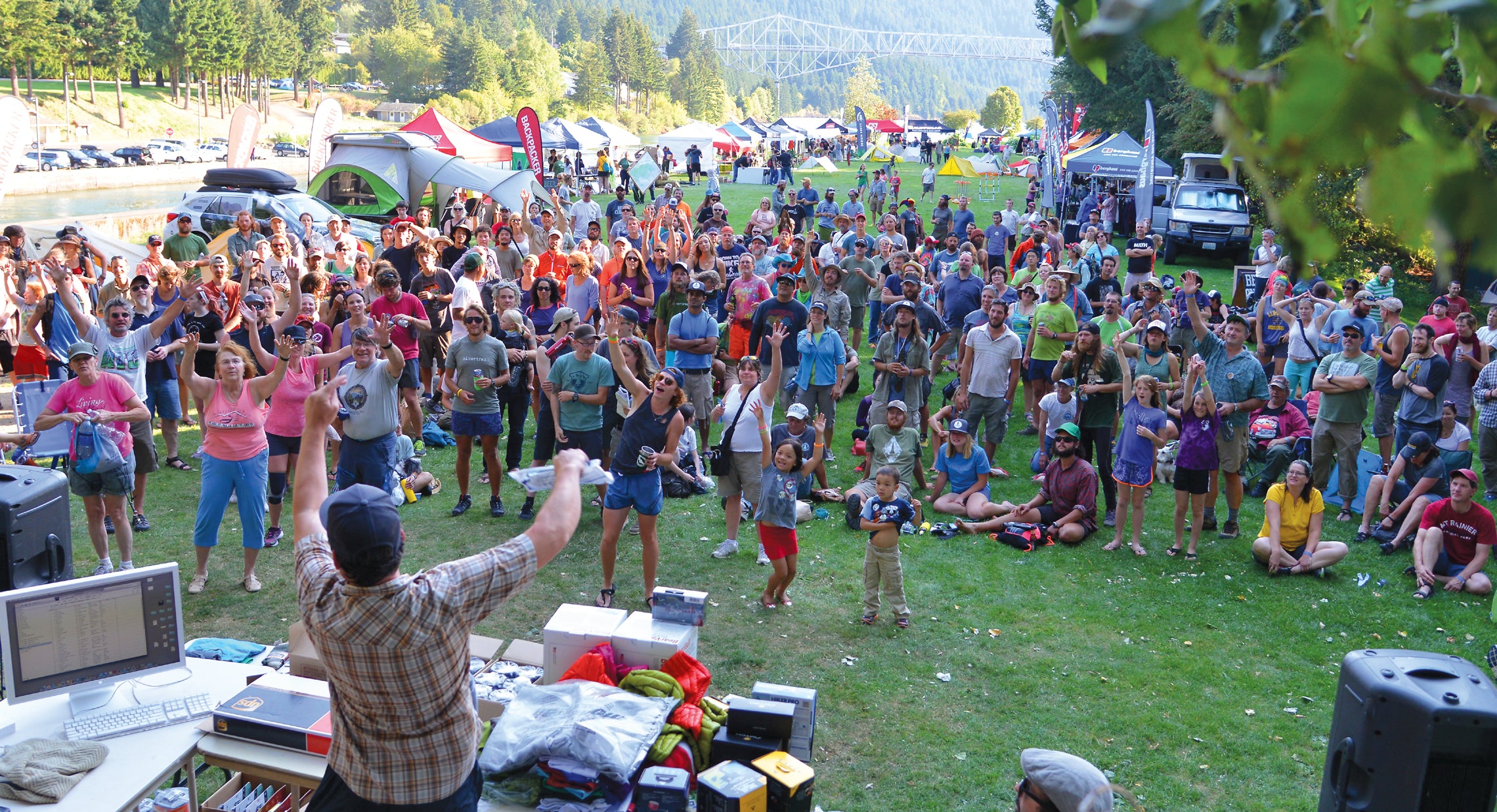 A large crowd of people reaching for prizes at a festival