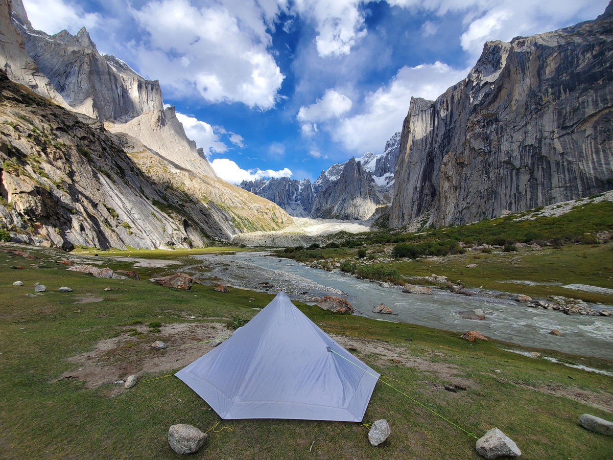 Gray Lunar Solo pitched in a green river valley below towering granite walls