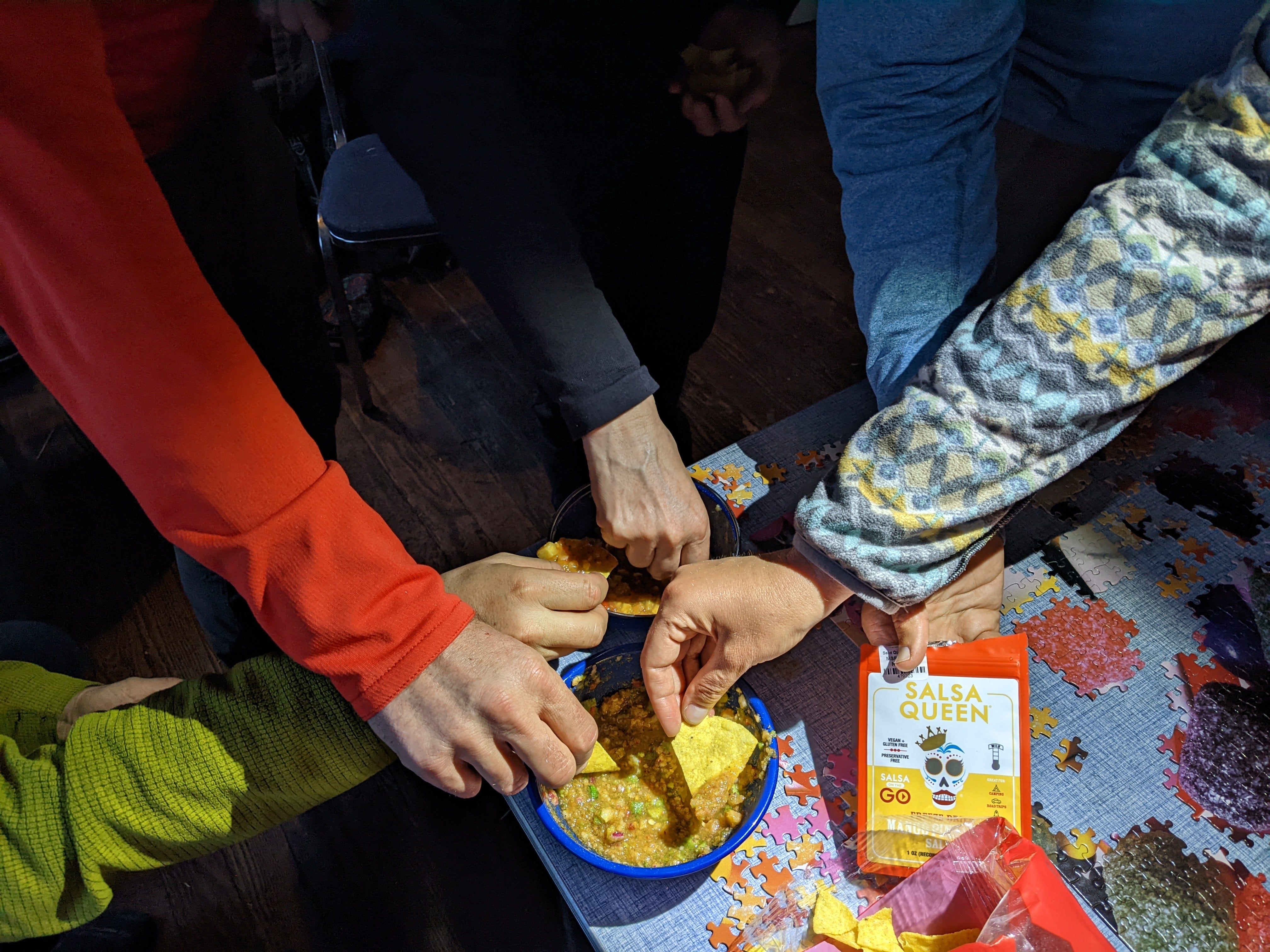 A group of hikers eating chips and salsa