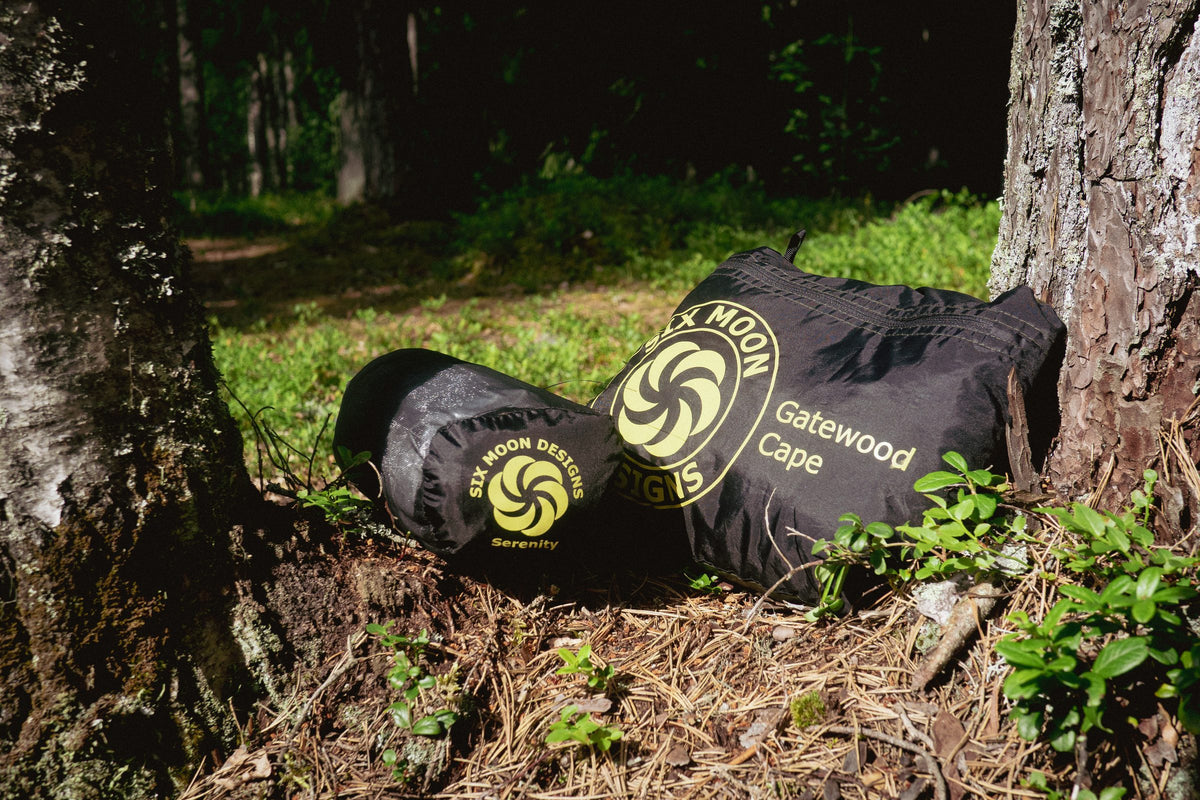 Serenity NetTent and Gatewood Cape stuff sacks at the base of a tree