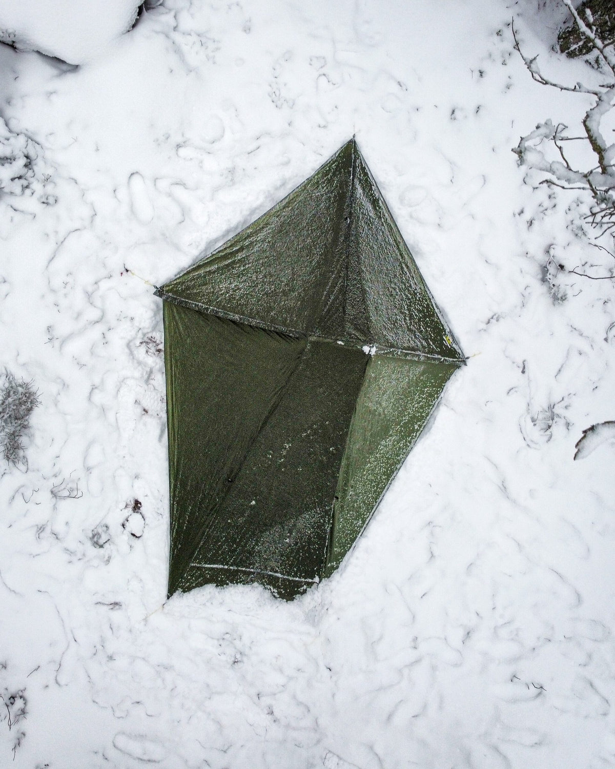 Overhead view of a green Skyscape Trekker pitched on snow